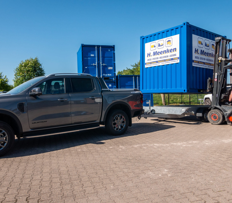 Kabelstapler belädt den PKW Anhänger mit Container